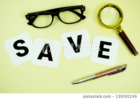 SAVE alphabet letters with magnifying glass, eye glasses and pen on yellow background 139392249