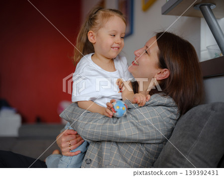 Mom, girl and hug with portrait on sofa for bonding with love, affection and childhood security for support. Mother, child and relax with care in living room of home, together and nurture connection Mom, girl and hug with portrait on sofa for bonding with love, affection and childhood security for support. Mother, child and relax with care in living room of home, together and nurture connection 139392431