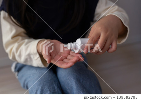一個孩子正在手上塗抹防曬乳。 一個孩子正在手上塗抹防曬乳。 139392795