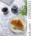 A scene of enjoying coffee and croissants for breakfast in the bright light by the window. 139392831