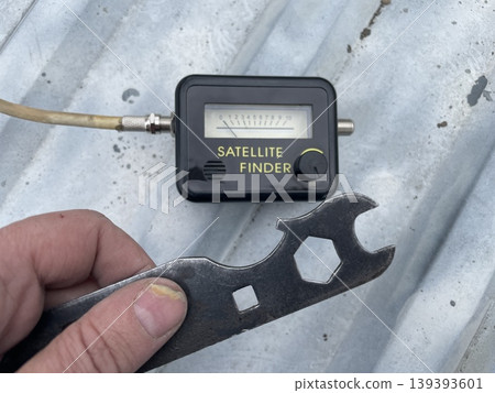 Adjusting satellite dish signal on rooftop Adjusting satellite dish signal on rooftop 139393601