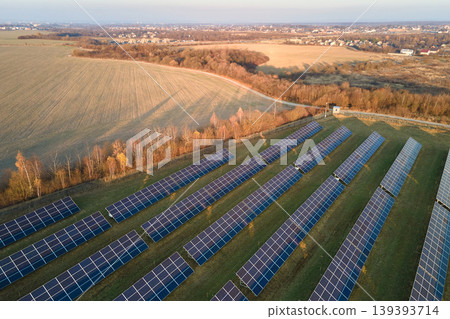 Aerial view of large sustainable electrical power plant with rows of solar photovoltaic panels for producing clean ecological electric energy. Renewable electricity with zero emission concept Aerial view of large sustainable electrical power plant with rows of solar photovoltaic panels for producing clean ecological electric energy. Renewable electricity with zero emission concept 139393714