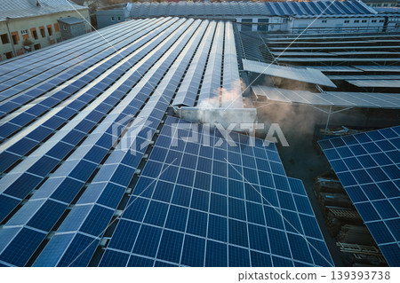 Aerial view of blue photovoltaic solar panels mounted on industrial building roof for producing green ecological electricity. Production of sustainable energy concept 139393738