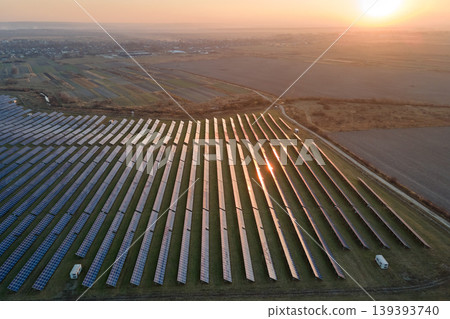 Aerial view of big sustainable electric power plant with many rows of solar photovoltaic panels for producing clean electrical energy at sunset. Renewable electricity with zero emission concept Aerial view of big sustainable electric power plant with many rows of solar photovoltaic panels for producing clean electrical energy at sunset. Renewable electricity with zero emission concept 139393740