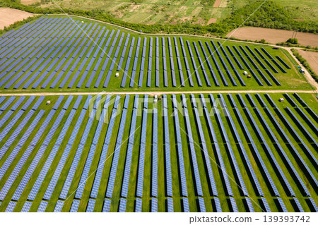 Aerial view of big sustainable electric power plant with many rows of solar photovoltaic panels for producing clean ecological electrical energy. Renewable electricity with zero emission concept. Aerial view of big sustainable electric power plant with many rows of solar photovoltaic panels for producing clean ecological electrical energy. Renewable electricity with zero emission concept. 139393742
