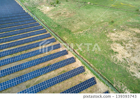Aerial view of big sustainable electric power plant with many rows of solar photovoltaic panels for producing clean ecological electrical energy. Renewable electricity with zero emission concept Aerial view of big sustainable electric power plant with many rows of solar photovoltaic panels for producing clean ecological electrical energy. Renewable electricity with zero emission concept 139393743
