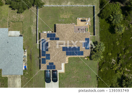 Aerial view of American home roof with blue solar photovoltaic panels for producing clean ecological electric energy. Renewable electricity with zero emission concept Aerial view of American home roof with blue solar photovoltaic panels for producing clean ecological electric energy. Renewable electricity with zero emission concept 139393749