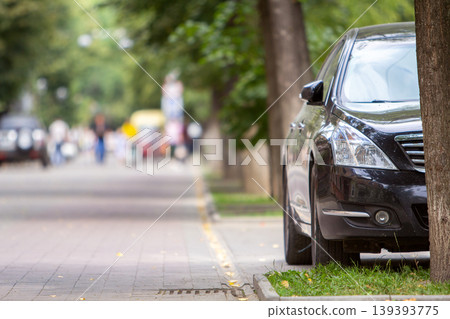 A car parked near curb on the side of the street on a parking lot. A car parked near curb on the side of the street on a parking lot. 139393775
