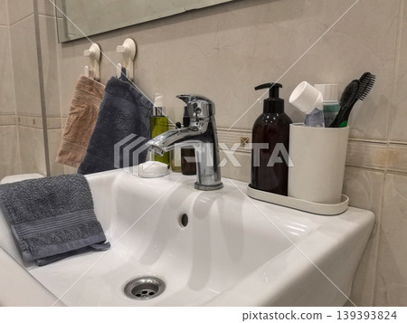 Clean Bathroom Sink with Soap Dispenser and Hanging Towels Clean Bathroom Sink with Soap Dispenser and Hanging Towels 139393824