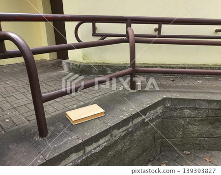 Single Book Resting on Concrete Ledge with Metal Railing Single Book Resting on Concrete Ledge with Metal Railing 139393827