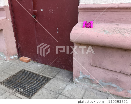 Pink jump rope resting on a textured wall ledge Pink jump rope resting on a textured wall ledge 139393831
