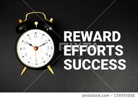 Reward Efforts And Success text with alarm clock on black background Reward Efforts And Success text with alarm clock on black background 139393888