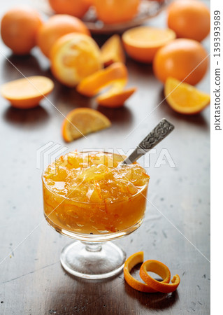 Orange jam in a glass dessert bowl on an old wooden table. Orange jam in a glass dessert bowl on an old wooden table. 139393989