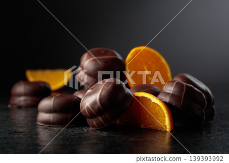 Chocolate dessert with slices of fresh oranges on a black background. Chocolate dessert with slices of fresh oranges on a black background. 139393992