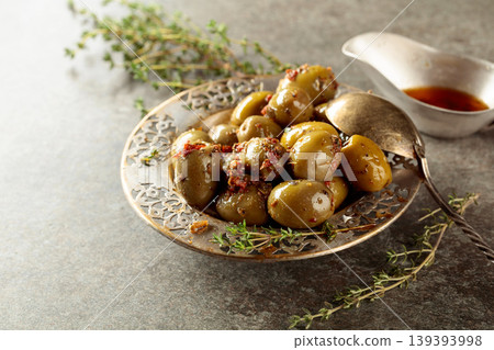 Bowl with olives and thyme twigs on a stone table. Bowl with olives and thyme twigs on a stone table. 139393998