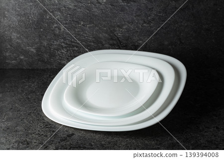 Empty white plates on a black stone background with copy space. Empty white plates on a black stone background with copy space. 139394008