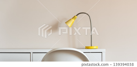 Minimal interior with yellow desk lamp on cabinet and chair Minimal interior with yellow desk lamp on cabinet and chair 139394038
