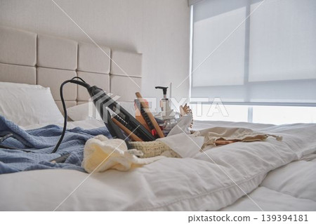 Hair straightener and beauty products on bed Hair straightener and beauty products on bed 139394181