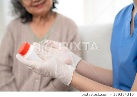 Asian woman nurse explaining medicine instruction to senior patient. 139394316