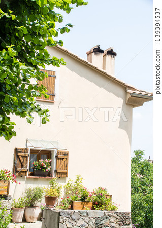 A building with pastel-colored walls bathed in bright sunlight on the French island of Corsica in the Mediterranean Sea. 139394537