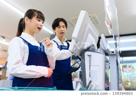Shop staff serving customers at the register Shop staff serving customers at the register 139394803