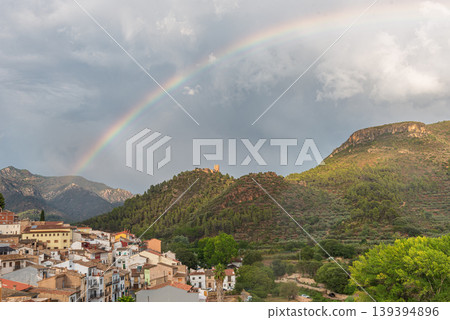 Small mountain village with a stormy sky and a large rainbow. Small mountain village with a stormy sky and a large rainbow. 139394896