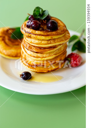 Delicious homemade pancakes with cherry strawberry and syrup topping Delicious homemade pancakes with cherry strawberry and syrup topping 139394934