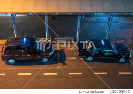 A taxi waiting for customers in the rotary in front of the station at night. A taxi waiting for customers in the rotary in front of the station at night. 139395007