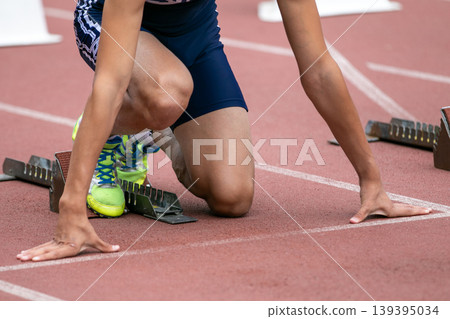 Athlete at low start from starting block Athlete at low start from starting block 139395034