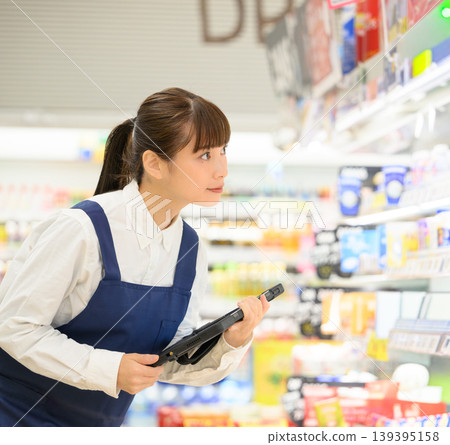 一名女子在商店裡檢查平板電腦。 一名女子在商店裡檢查平板電腦。 139395158