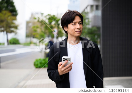 拿著智慧型手機的微笑的人 139395184