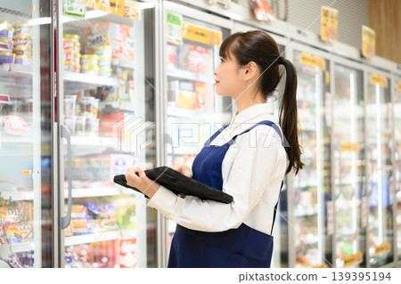Female clerk working in a supermarket Female clerk working in a supermarket 139395194