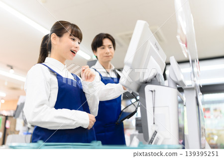 Male and female store clerks working at the cash register 139395251