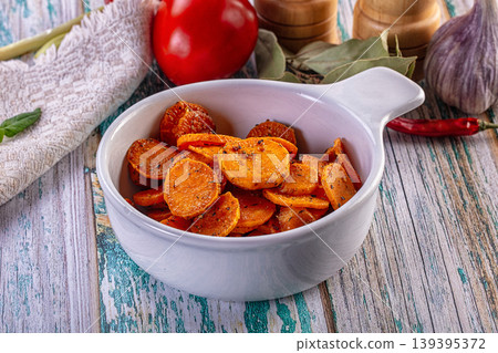 Roasted carrot slices with herbs in a white bowl on a rustic wooden background. Roasted carrot slices with herbs in a white bowl on a rustic wooden background. 139395372