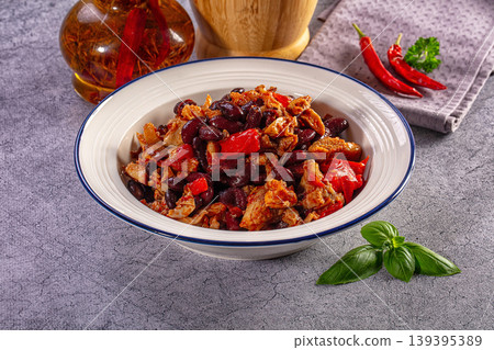 Hearty stew with meat, red kidney beans, and bell peppers in a ceramic bowl on a rustic table Hearty stew with meat, red kidney beans, and bell peppers in a ceramic bowl on a rustic table 139395389