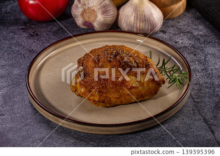 Roasted chicken thigh with crispy skin and rosemary on a ceramic plate Roasted chicken thigh with crispy skin and rosemary on a ceramic plate 139395396