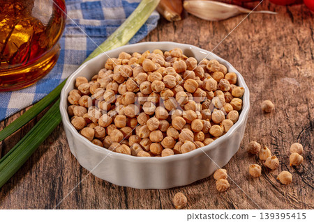 Dried Chickpeas in White Bowl on Rustic Wooden Table with Ingredients Dried Chickpeas in White Bowl on Rustic Wooden Table with Ingredients 139395415