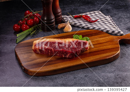 Raw beef steak with basil, cherry tomatoes, garlic, chili, wooden board Raw beef steak with basil, cherry tomatoes, garlic, chili, wooden board 139395427