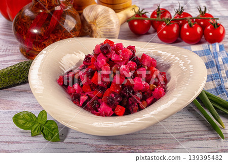 Traditional Russian vinaigrette salad with beetroot and fresh vegetable ingredients on wooden table 139395482