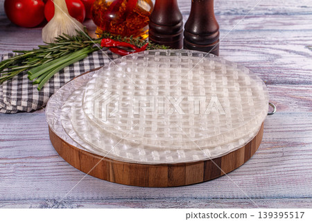 Raw rice paper for spring rolls with fresh vegetables and herbs on rustic wooden background Raw rice paper for spring rolls with fresh vegetables and herbs on rustic wooden background 139395517