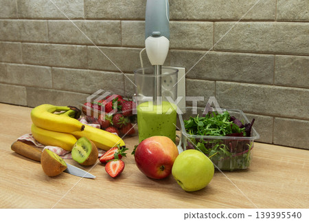 Preparing a healthy green smoothie with fresh fruits 139395540