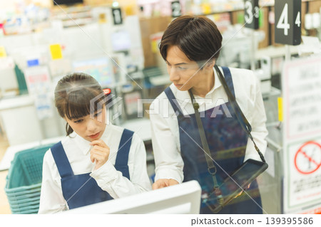 Store clerk checks tablet 139395586