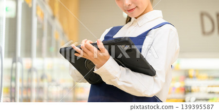 Female store clerk operating a tablet Female store clerk operating a tablet 139395587