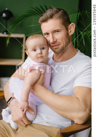Father Holding Baby Daughter And Looking Proudly At Camera Father Holding Baby Daughter And Looking Proudly At Camera 139395648