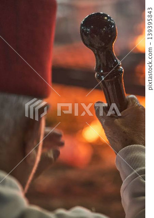 Hand holding traditional staff near fire during Samaritan Passover ritual Hand holding traditional staff near fire during Samaritan Passover ritual 139395843