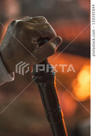 Hand holding traditional staff near fire during Samaritan Passover ritual Hand holding traditional staff near fire during Samaritan Passover ritual 139395844