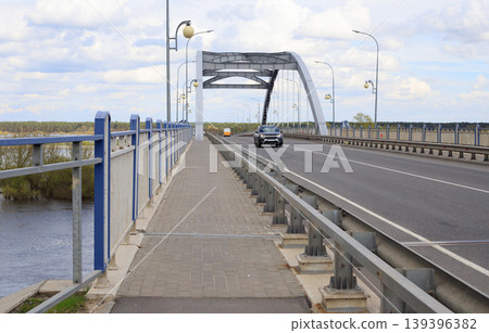 Arch bridge over the river during spring flood. Cargo transportation and logistics concept. Arch bridge over the river during spring flood. Cargo transportation and logistics concept. 139396382
