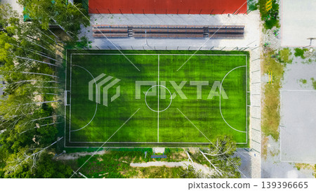 Aerial view of a green soccer field with trees and bleachers nearby Aerial view of a green soccer field with trees and bleachers nearby 139396665
