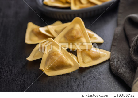 Triangular Ravioli Pasta Close-Up on Dark Surface Uncooked Filled Italian Dumplings for Cooking Triangular Ravioli Pasta Close-Up on Dark Surface Uncooked Filled Italian Dumplings for Cooking 139396752