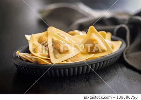 Fresh Triangular Ravioli On Black Plate - Golden Filled Pasta For Italian Cooking And Food Photography Fresh Triangular Ravioli On Black Plate - Golden Filled Pasta For Italian Cooking And Food Photography 139396756